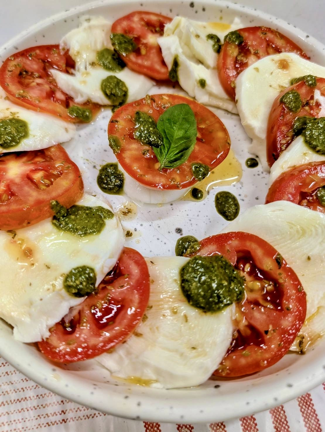 Caprese salad with mozzarella, tomatoes and basil pesto